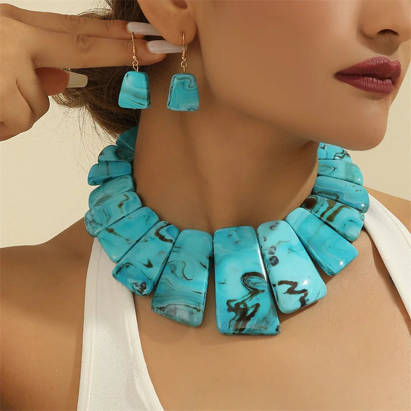 woman wearing bold necklace and earrings